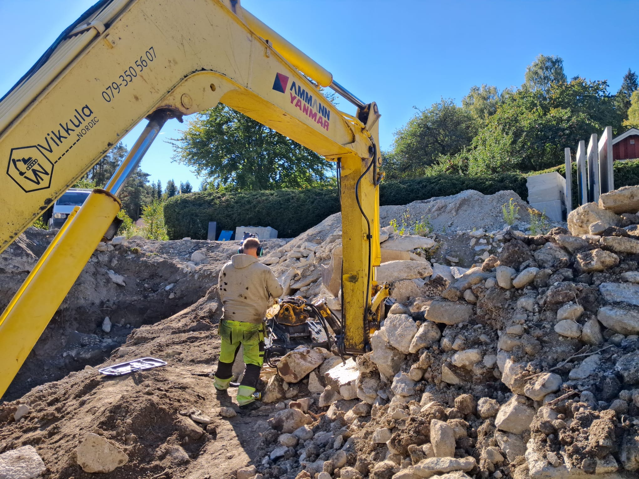 Mekaniker servar tiltrotator på Vikkula Nordics grävmaskin i fält